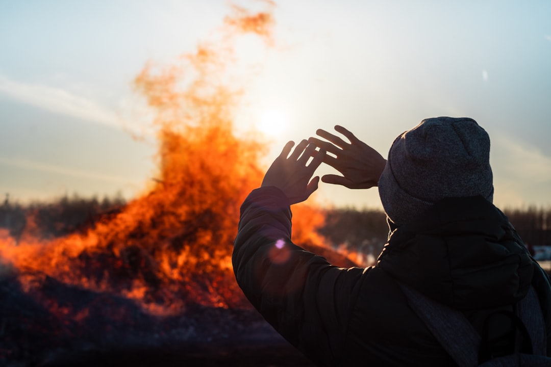 burn-out signalen herkennen — person in black jacket covering face with hands