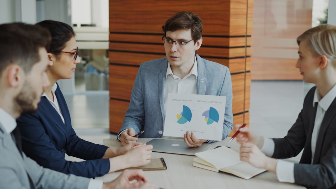 performance management cyclus — Man presenting charts to colleagues in a meeting.